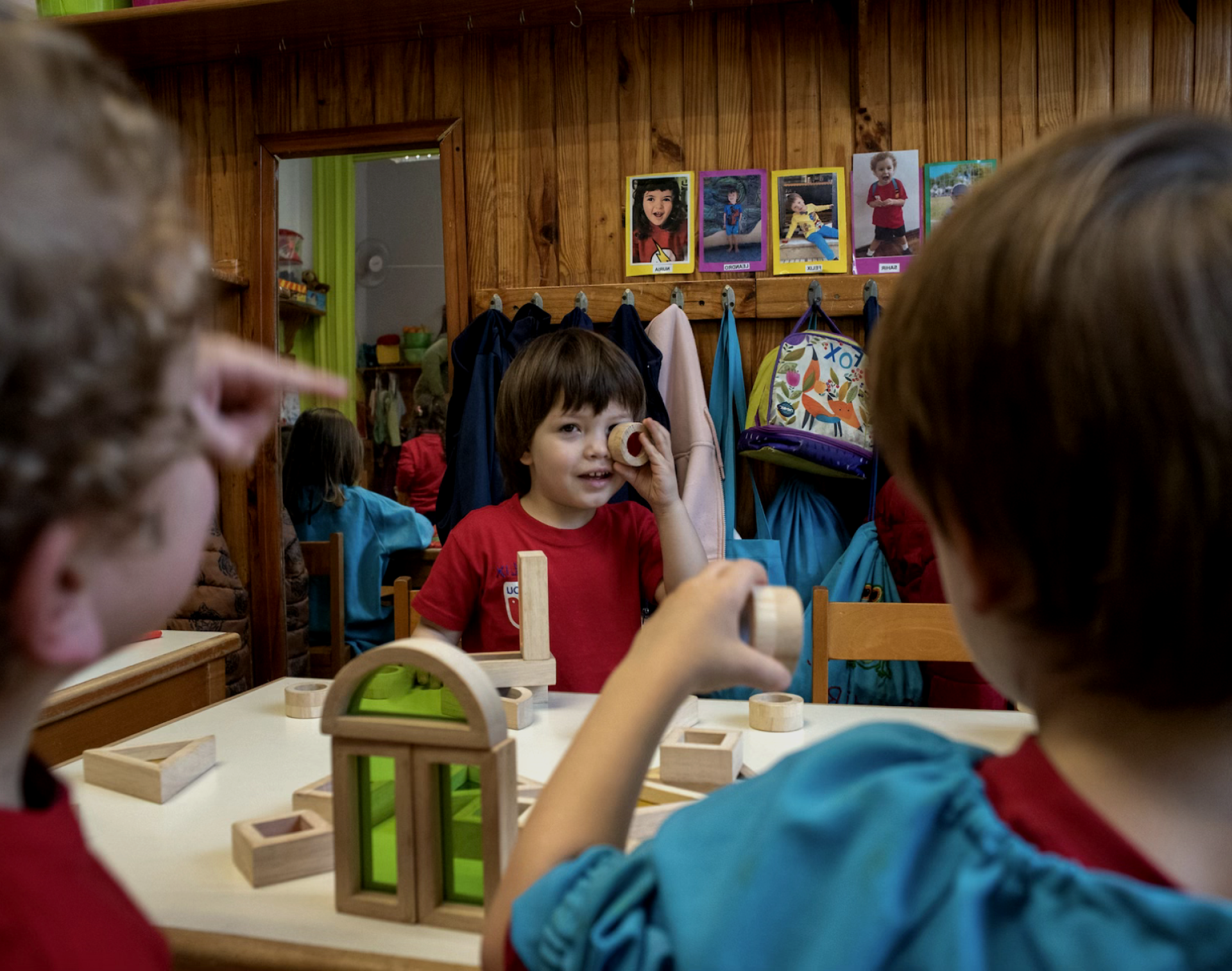 Niños jugando en un aula con juguetes de madera